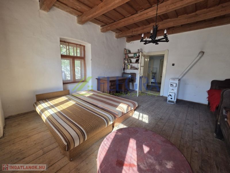 Schlafzimmer in einem Einfamilienhaus mit einem Bett und einem Boden in Holzoptik.