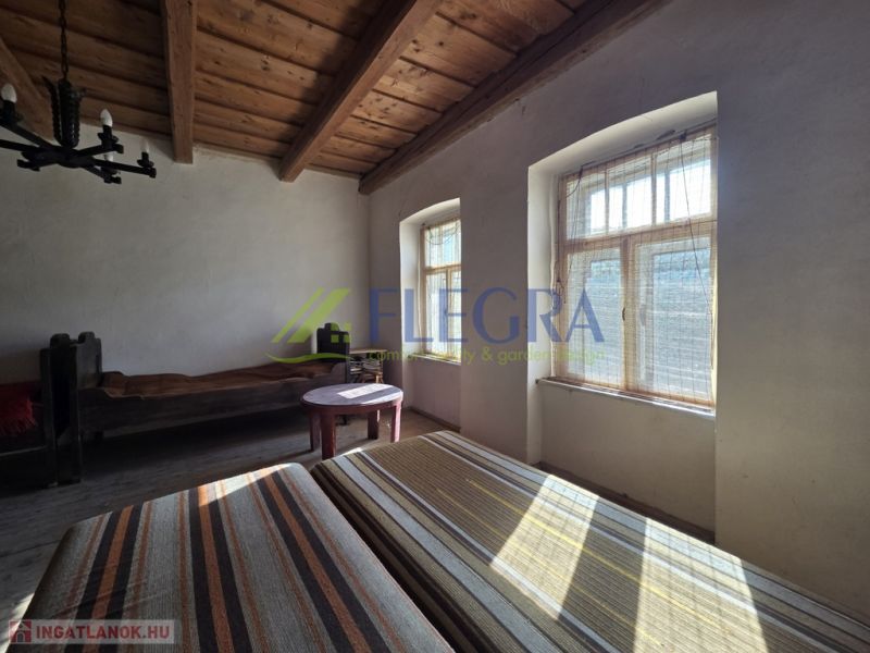 Ein Zimmer in einem Einfamilienhaus mit Holzbalkendecken und natürlichem Licht.