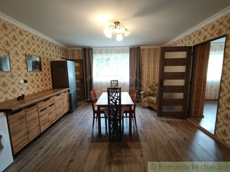 Esszimmer in einem Einfamilienhaus mit Tapeten und Boden in Holzoptik.