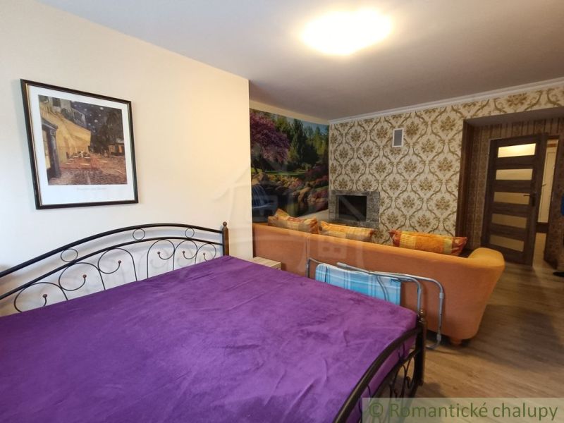 Schlafzimmer in einem Einfamilienhaus mit violetter Decke, Sofa und Kamin.