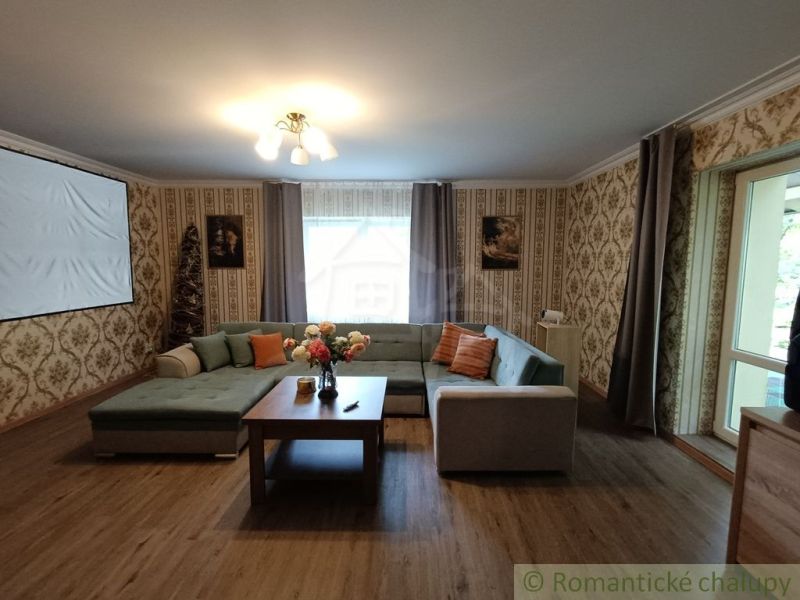Wohnzimmer in einem Einfamilienhaus mit Sofa, Holzboden und Projektor.