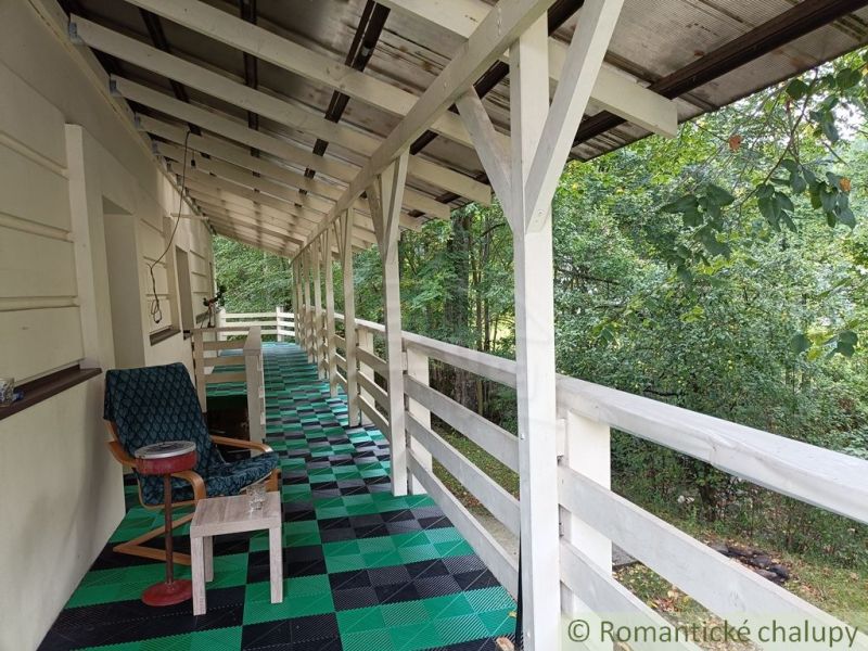 Die Veranda des Einfamilienhauses in Staškov mit einem farbigen Boden und Blick ins Grüne.