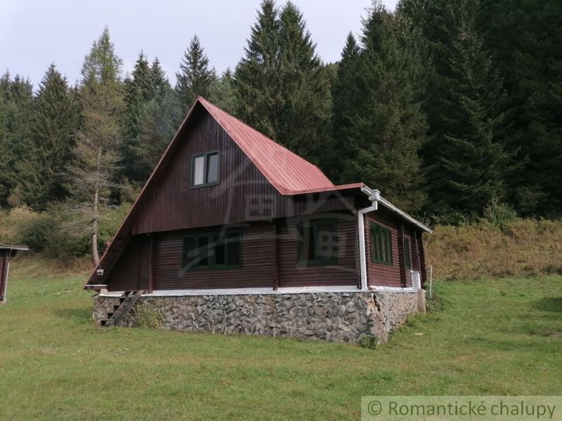 Eine Hütte in Rajecká Lesná, umgeben von Wald, mit einem Steinfundament und einem Dach.