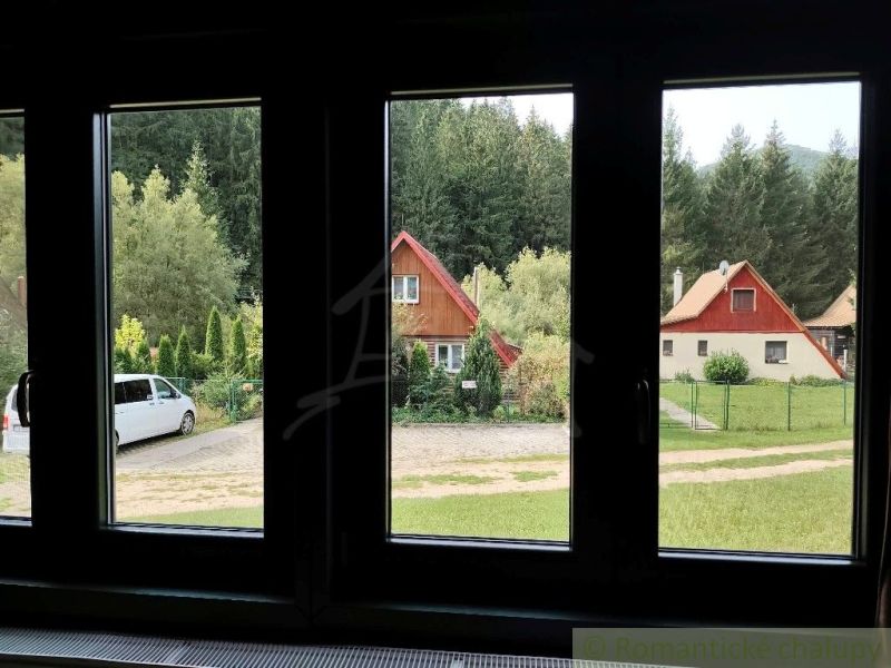 Blick auf die Hütten in Rajecká Lesná, umgeben von Grün und Autos.