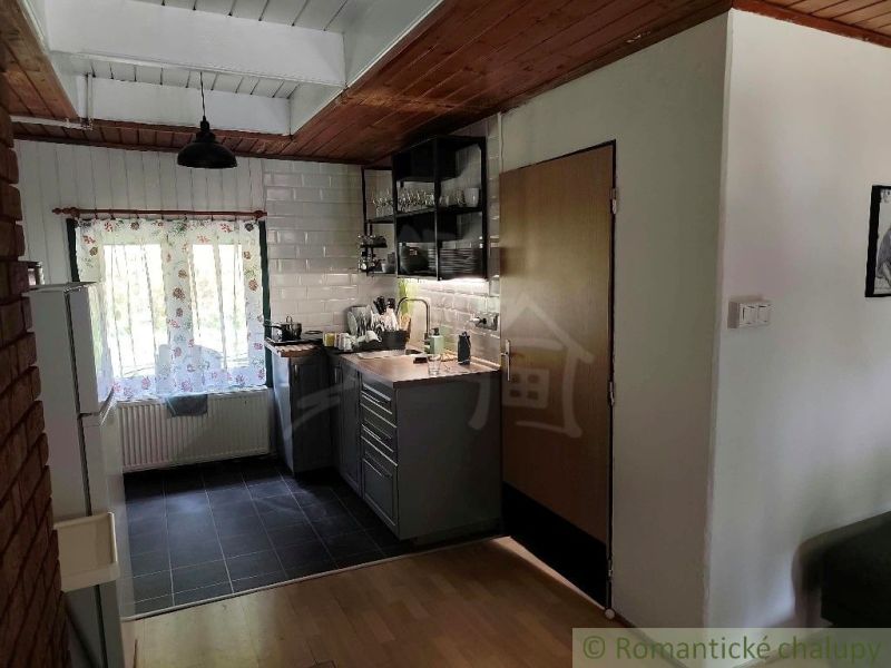 Küchenbereich in der Hütte mit Holzboden und Ziegelwanddekor.