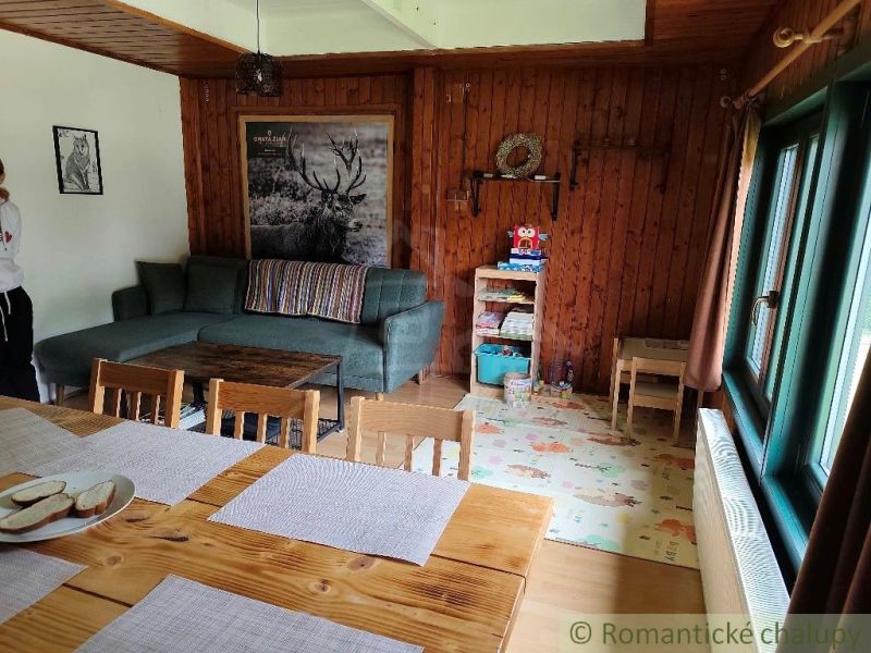 Holzinterieur der Hütte mit Sofa, Tisch und Spielzeug auf dem Boden mit Holzdekor.