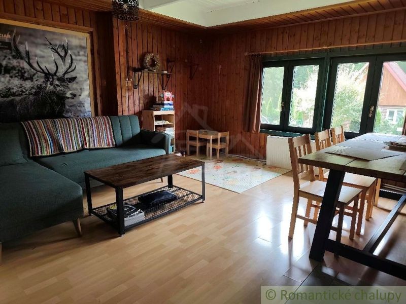 Wohnzimmer in einer Hütte mit gemütlicher Sitzecke und Boden in Holzoptik.