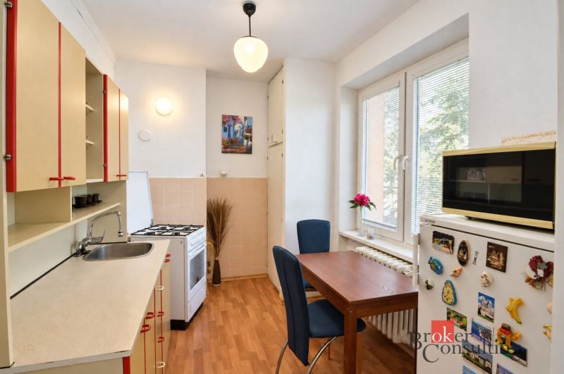 Küche in einer 2-Zimmer-Wohnung mit Holzboden, Esstisch und moderner Ausstattung.