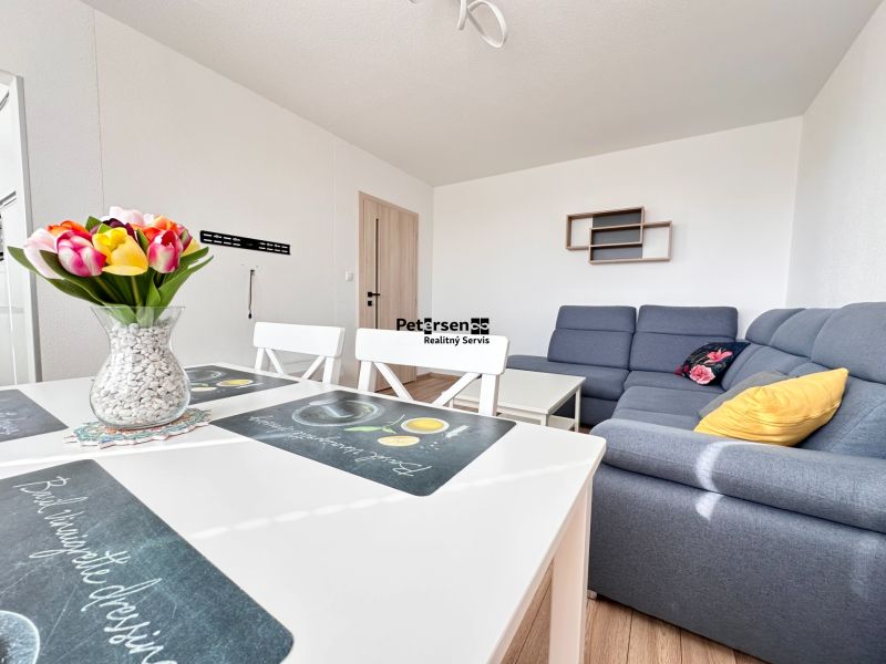 Wohnzimmer in einer 3-Zimmer-Wohnung mit Holzboden und einer bequemen Couch.