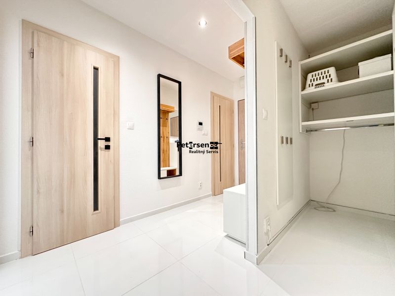 Helles Vorzimmer in einer 3-Zimmer-Wohnung mit weißem Boden und Spiegel.
