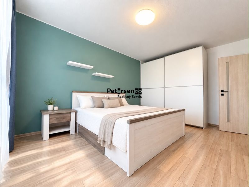 Schlafzimmer in einer 3-Zimmer-Wohnung mit Bett, Nachttisch und Boden mit Holzdekor.