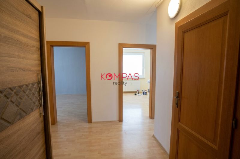 Der Flur in der 3-Zimmer-Wohnung mit einem Boden in Holzoptik und hellen Türen.