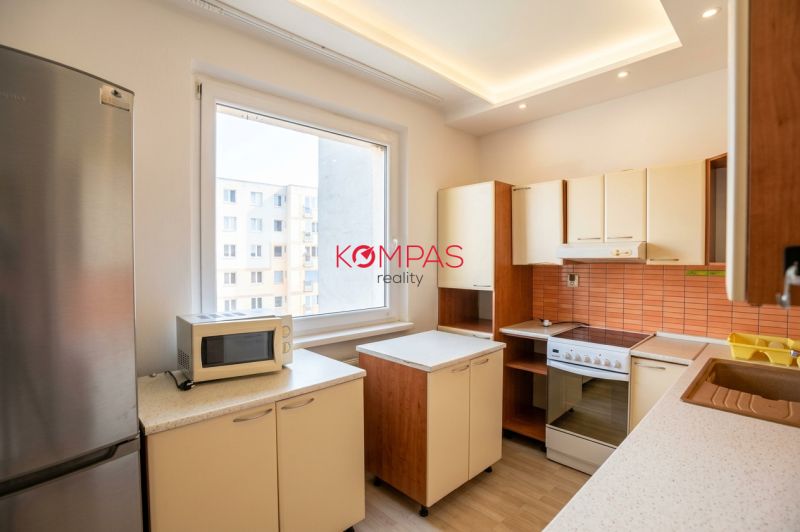 Küche in einer 3-Zimmer-Wohnung mit Holzboden und Geräten.