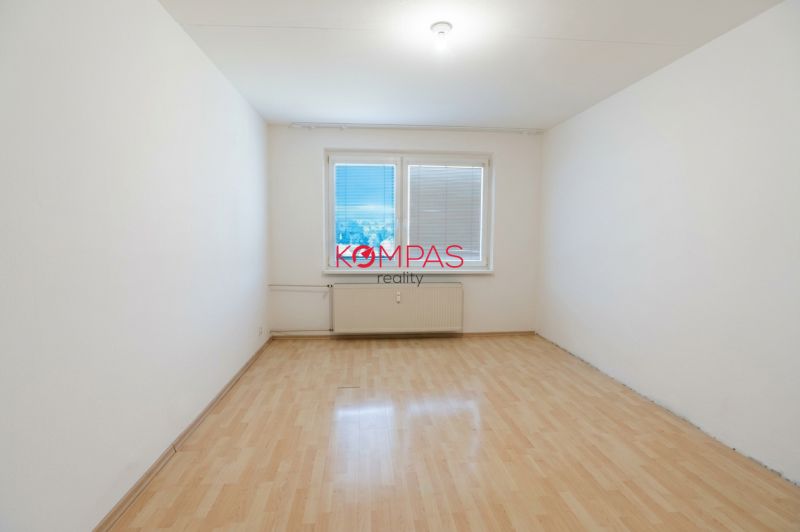Ein Zimmer in einer 3-Zimmer-Wohnung mit einem Holzboden und einem großen Fenster.