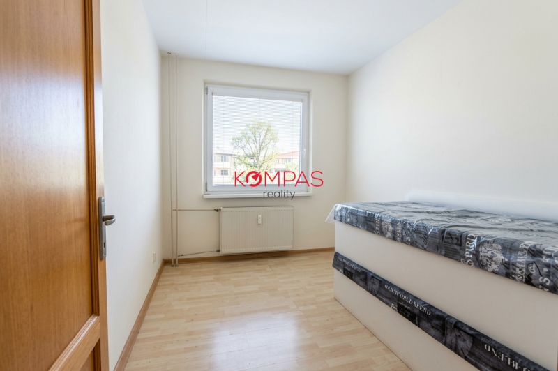 Helles Zimmer in einer 3-Zimmer-Wohnung mit Holzboden und Bett.