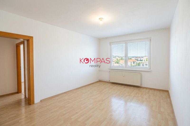 Ein Zimmer in einer 3-Zimmer-Wohnung mit einem großen Fenster und einem Boden in Holzoptik.