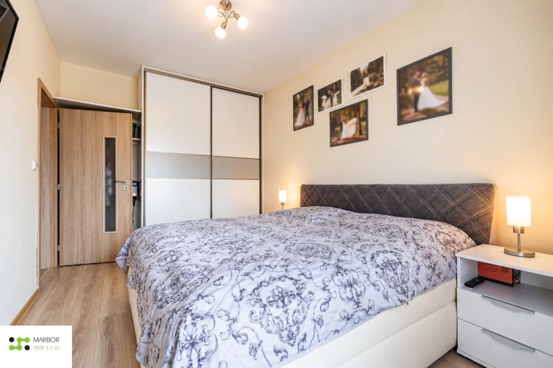 Schlafzimmer mit Einbauschrank, in einer 3-Zimmer-Wohnung; Boden mit Holzdekor.