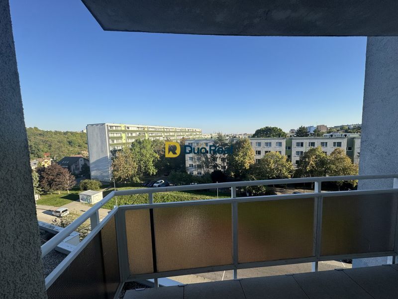 Blick vom Balkon auf Wohnhäuser und Grünflächen in Karlova Ves am Platz des hl. Franziskus.