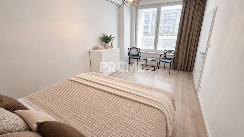 Helles Schlafzimmer in einer 2-Zimmer-Wohnung mit Holzboden und einfacher Einrichtung.
