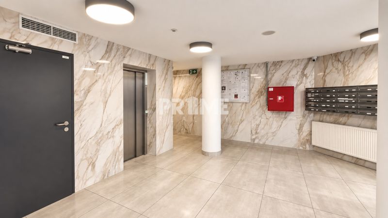 Eingangshalle mit Marmorstiegen, Briefkästen und Aufzug in einer 2-Zimmer-Wohnung.