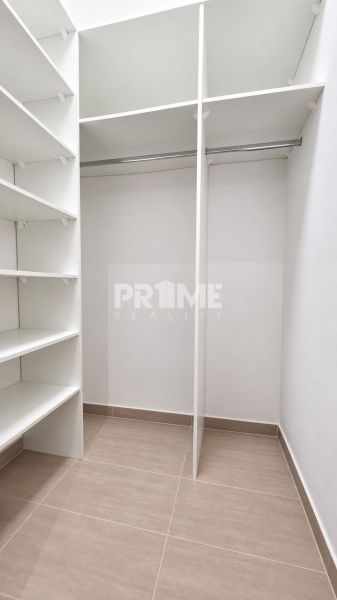 Ein Kleiderschrank mit Regalen und Kleiderstange in einer 2-Zimmer-Wohnung.