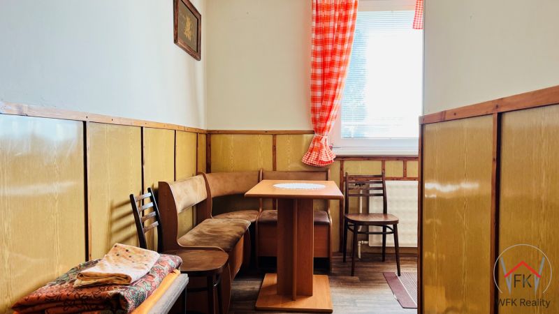 Küchenzeile in einer 3-Zimmer-Wohnung mit Holzdekor und Sitzgelegenheit mit Tisch.