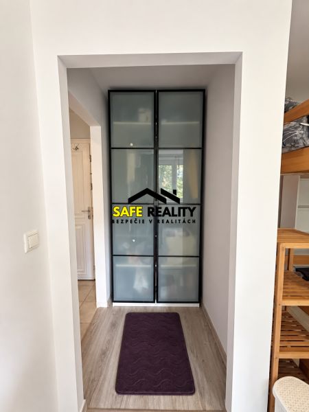 Ein enger Flur mit Holzboden und einem Einbauschrank in einer Einzimmerwohnung.