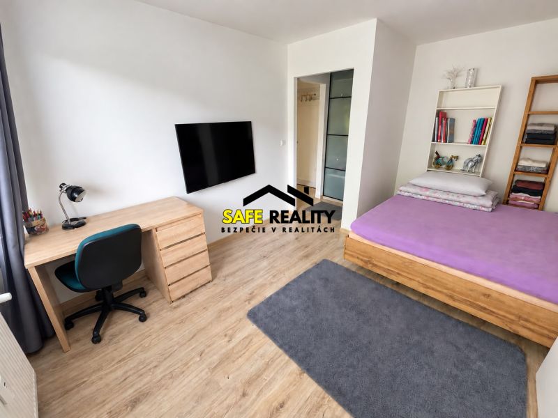 Innenraum einer Einzimmerwohnung mit Tisch, Fernseher und Bett, Boden mit Holzdekor.