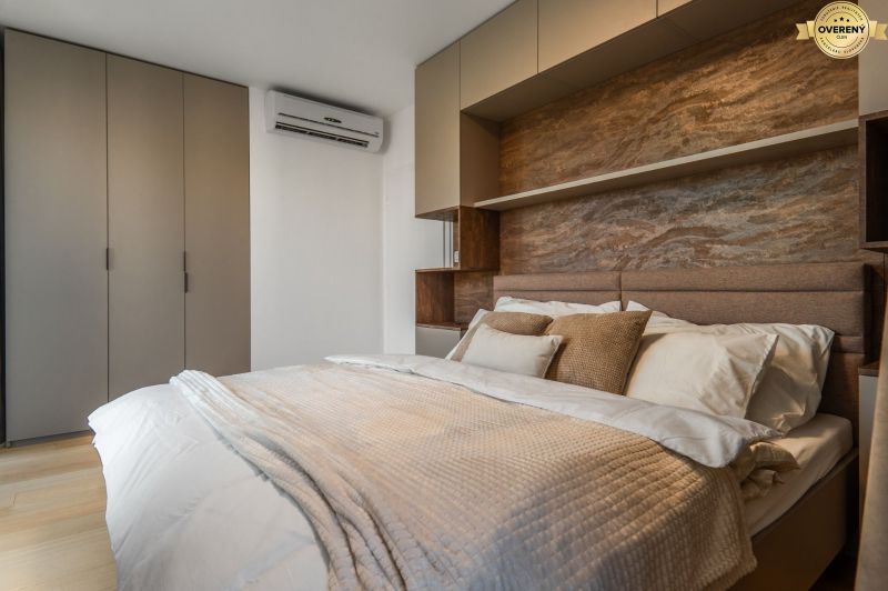 Schlafzimmer mit Doppelbett, Einbauschränken und Boden mit Holzdekor. Wohnungsbau.
