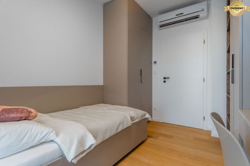 Einzelzimmer mit Bett, Einbauschrank und Boden mit Holzdekor.