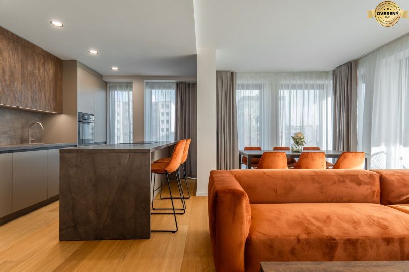 Innenraum mit Holzboden, orangefarbenem Sofa und Esstisch. Wohnungsbau.