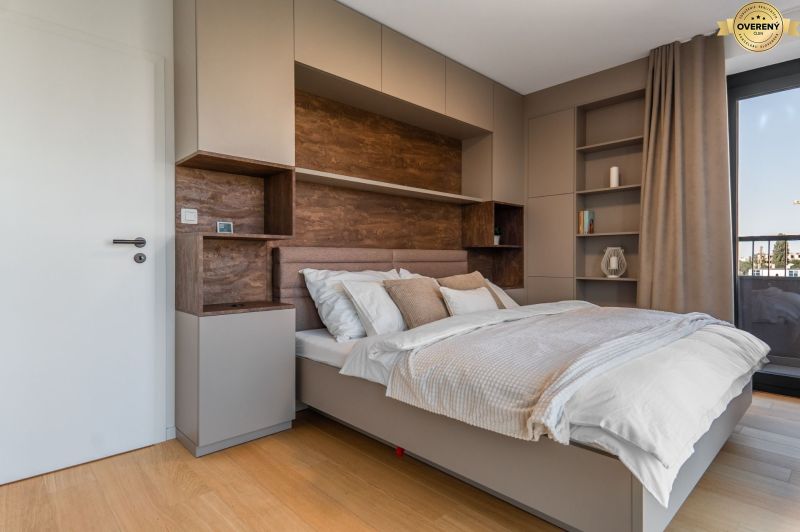 Schlafzimmer in einer Wohnung mit modernen Schränken und einem Boden in Holzoptik.
