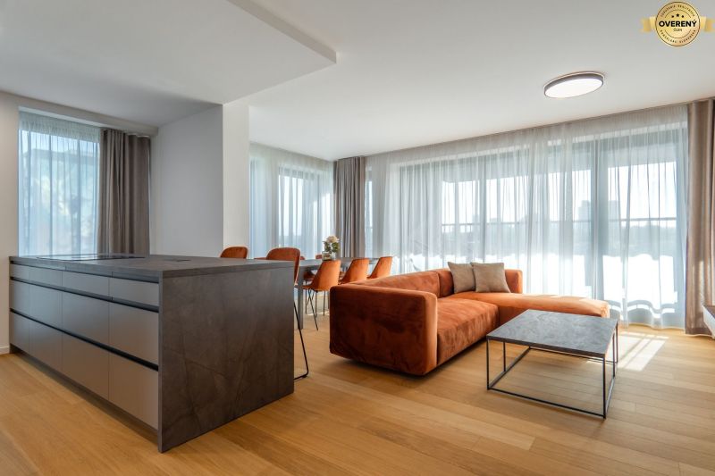 Wohnzimmer mit einem orangefarbenen Sofa, einem Boden in Holzoptik und einem Tisch im Wohnzimmer.