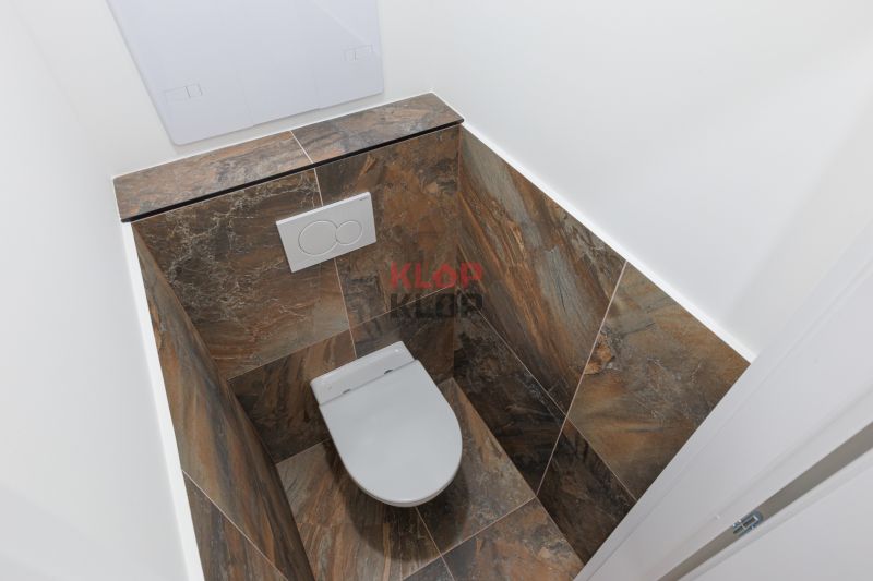 Toilette gefliest mit Keramikfliesen in einer 2-Zimmer-Wohnung.