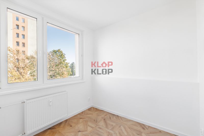 Ein Zimmer mit hellen Wänden und einem Boden in Holzoptik, 2-Zimmer-Wohnung.