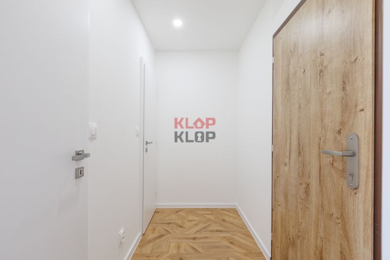 Flur mit Türen und Boden in Holzoptik, 2-Zimmer-Wohnung.