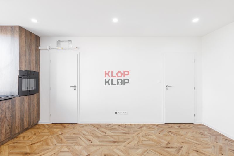 Innenraum einer 2-Zimmer-Wohnung mit Küche und Holzboden.