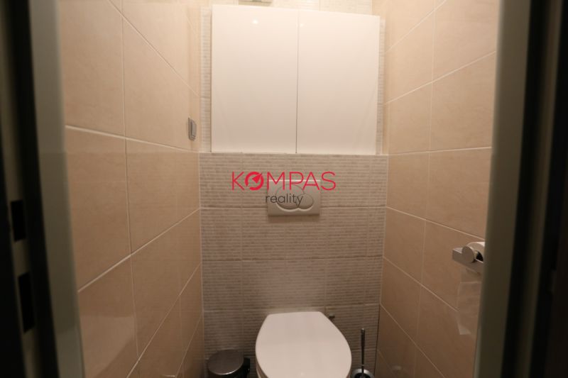 Badezimmer mit hängender Toilette und Fliesen in einer 2-Zimmer-Wohnung.