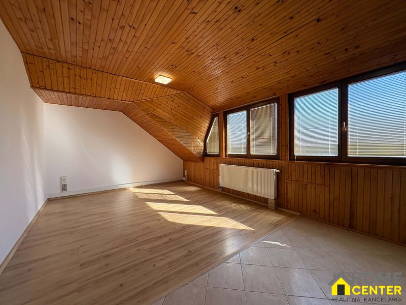 Dachzimmer mit Holzwänden und Holzboden mit Holzdekor in einer 3-Zimmer-Wohnung.