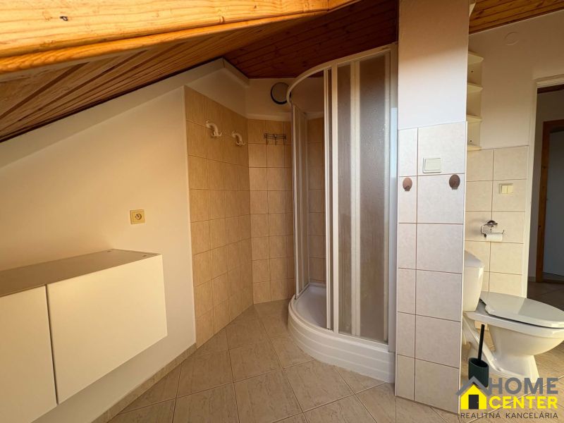 Badezimmer in einer 3-Zimmer-Wohnung mit Eckdusche und Fliesen in Holzoptik.