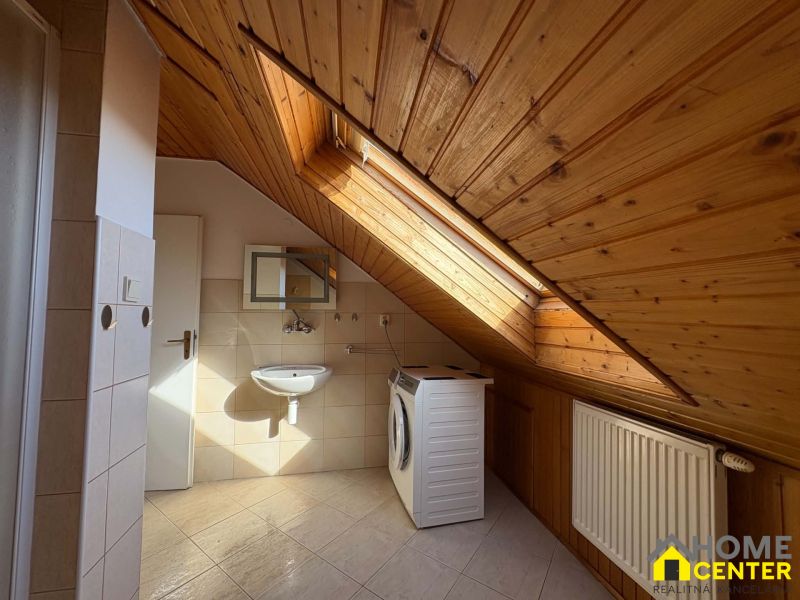 Badezimmer mit Holzbodenoptik und Dachfenster in einer 3-Zimmer-Wohnung.