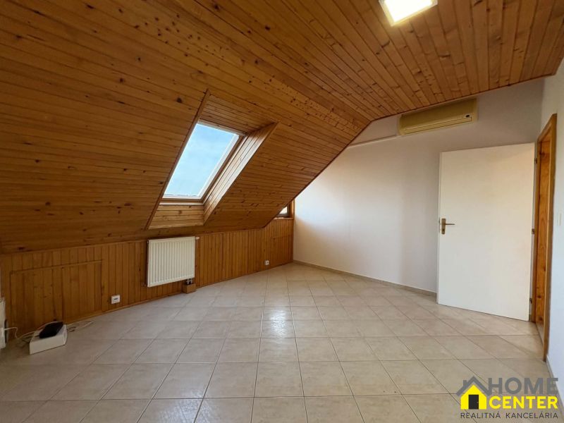 Dachgeschosszimmer mit Holzverkleidung und Dachfenstern in einer 3-Zimmer-Wohnung.