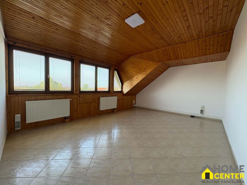 Ein sauberes Zimmer mit Holzelementen, Heizkörpern und großen Fenstern in einer 3-Zimmer-Wohnung.