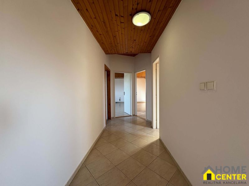 Flur einer 3-Zimmer-Wohnung mit Holzbalkendecke und Fliesenboden.