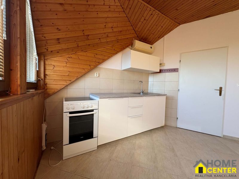 Küche in einer 3-Zimmer-Wohnung mit Holzboden und schräger Decke.