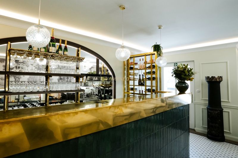Innenraum von Geschäftsräumen mit glänzender Bar, hängenden Gläsern und dekorativer Beleuchtung.