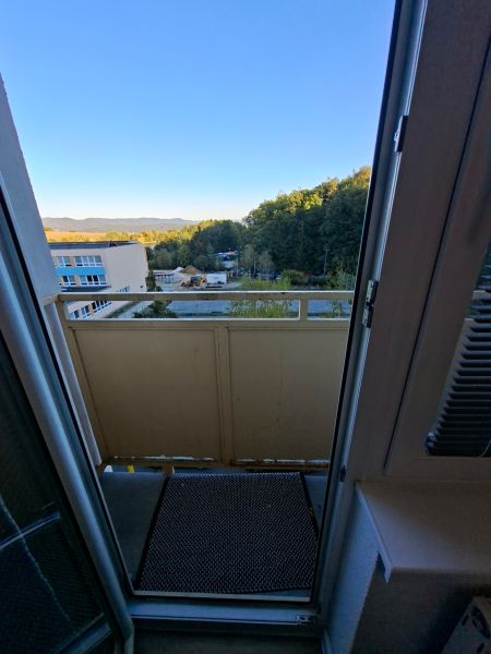 Blick vom Balkon einer Einzimmerwohnung in der Školská-Straße in Kanianka mit Waldkulisse.