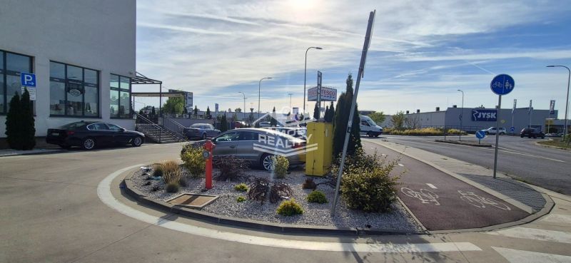 Javorová Straße in Malacky, Geschäfte wie Tesco und Jysk, Parkplatz und Radweg.