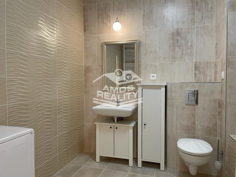 Badezimmer in einer 2-Zimmer-Wohnung mit Fliesen und weißen Sanitäreinrichtungen.