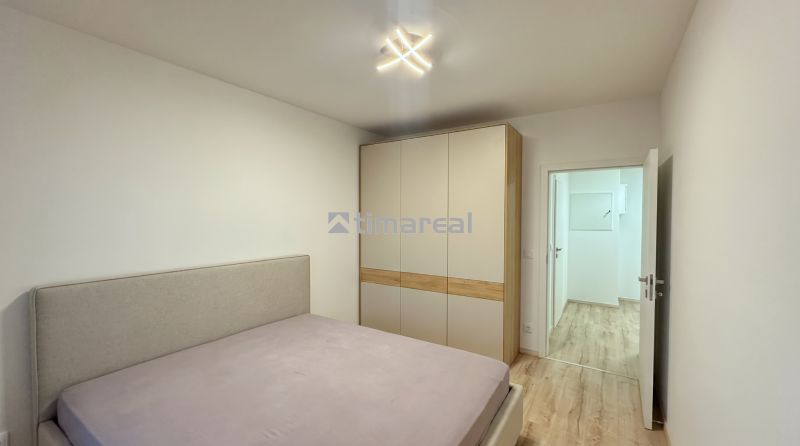 Helles Schlafzimmer mit Bett und Einbauschrank in einer 2-Zimmer-Wohnung.